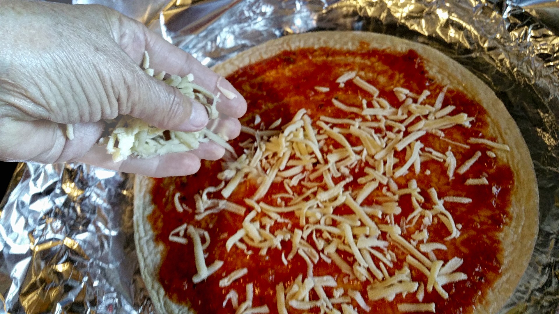 adding-cheese-to-homemade-pizza